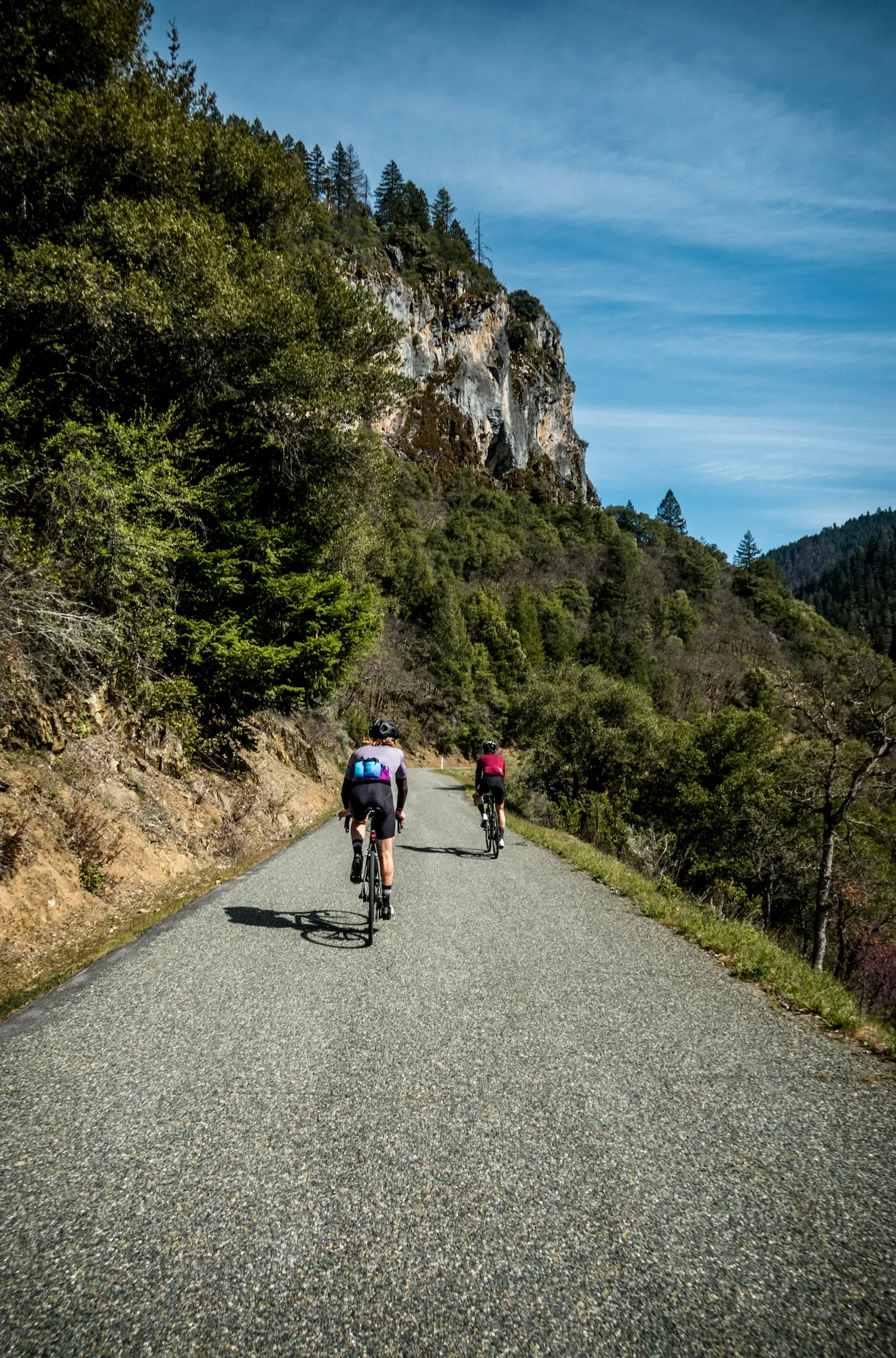 Sortie cycliste dans les gorges du Verdon, avec deux personnes grimpant une route tranquille au cœur d’un paysage escarpé.