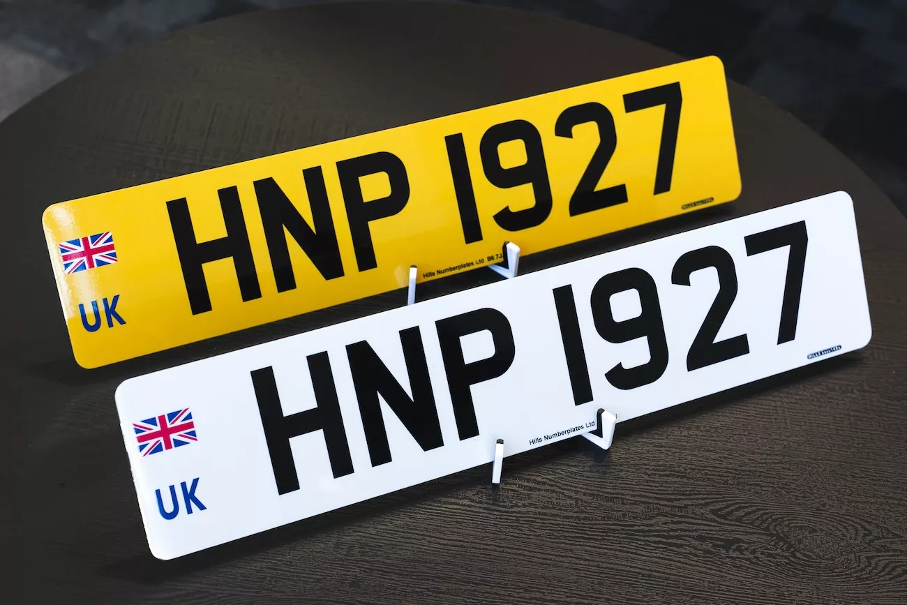 DVLA-compliant front and rear acrylic number plates displayed on stands, supplied by uGroup UK