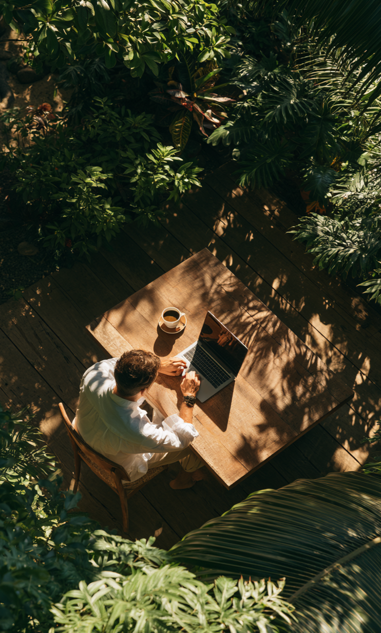 A founder working on a laptop at a garden table, away from the office