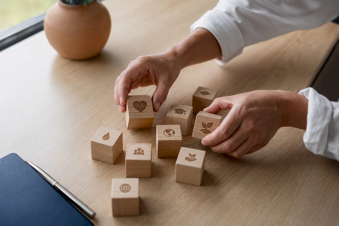 Des mains qui organisent des blocs représentant l'impact social