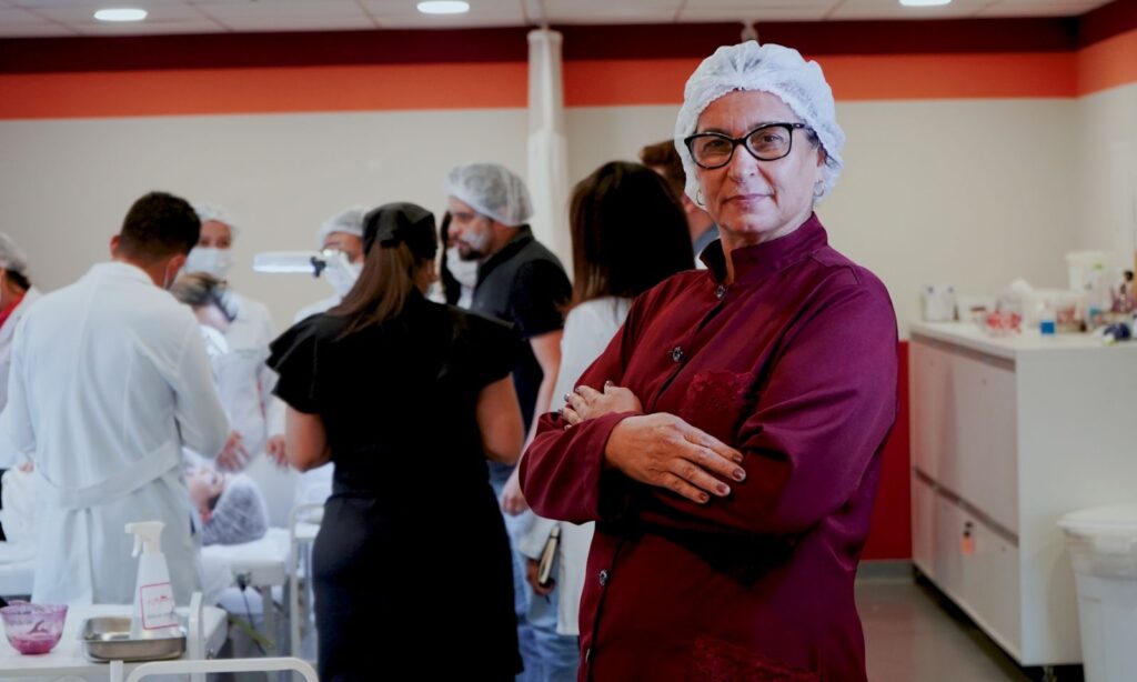 Dra. Floripes Antônia Carmo, aos 59 anos, ex-biomédica de mais de 20 anos, decide mudar de área após contrair Covid e se recuperar com sequelas, escolhendo a biomedicina estética por amor ao cuidado às pessoas e busca por liberdade.