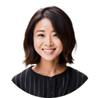 Portrait d'une femme asiatique souriante avec des cheveux courts et bruns, portant une chemise à rayures noires.