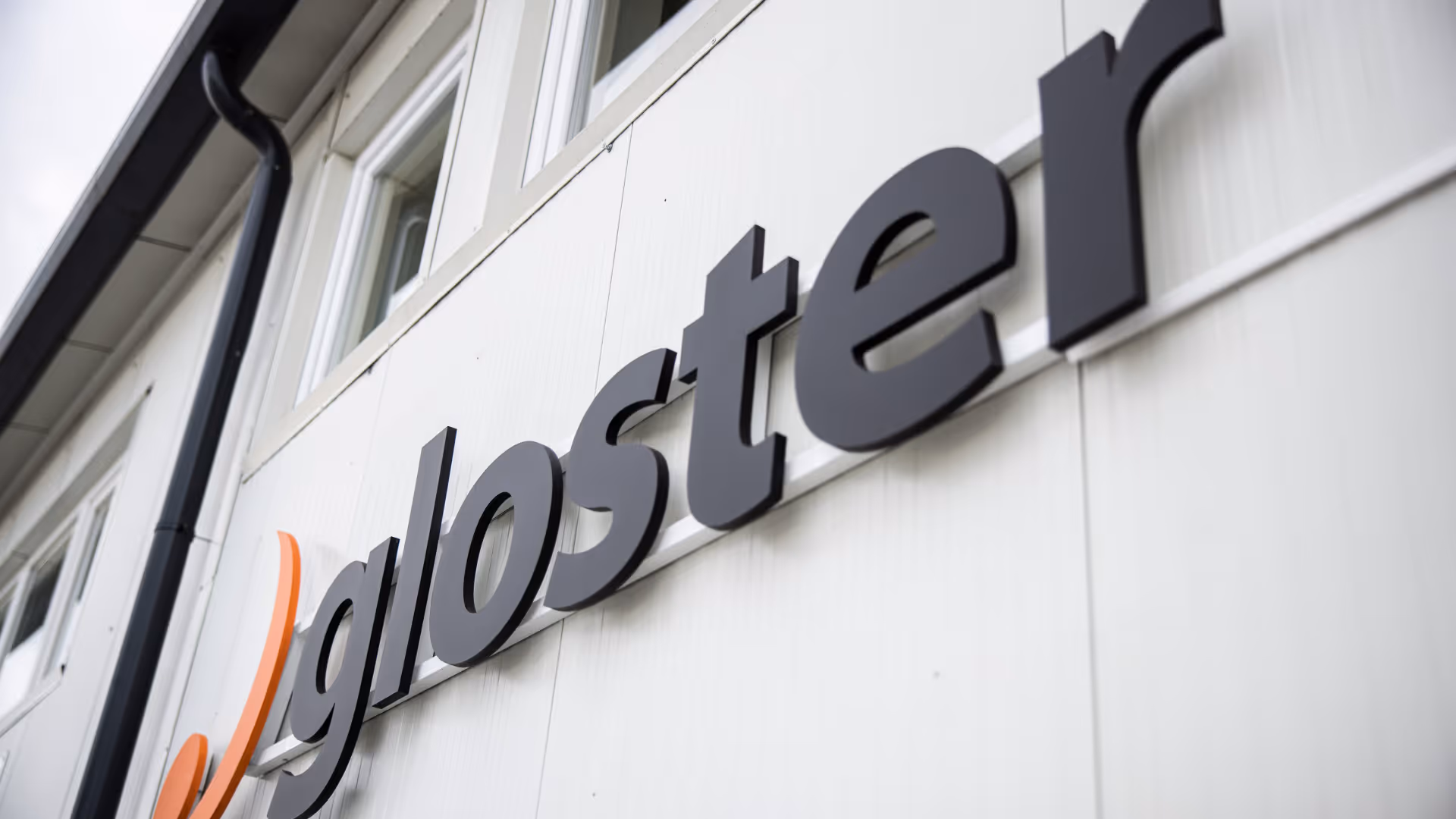 Gloster logó egy épület oldalán, közelről, jobb oldalról fotózva