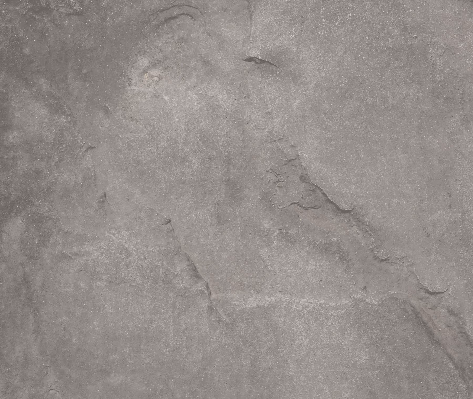 Close-up of gray concrete with natural cracks and rough patches.