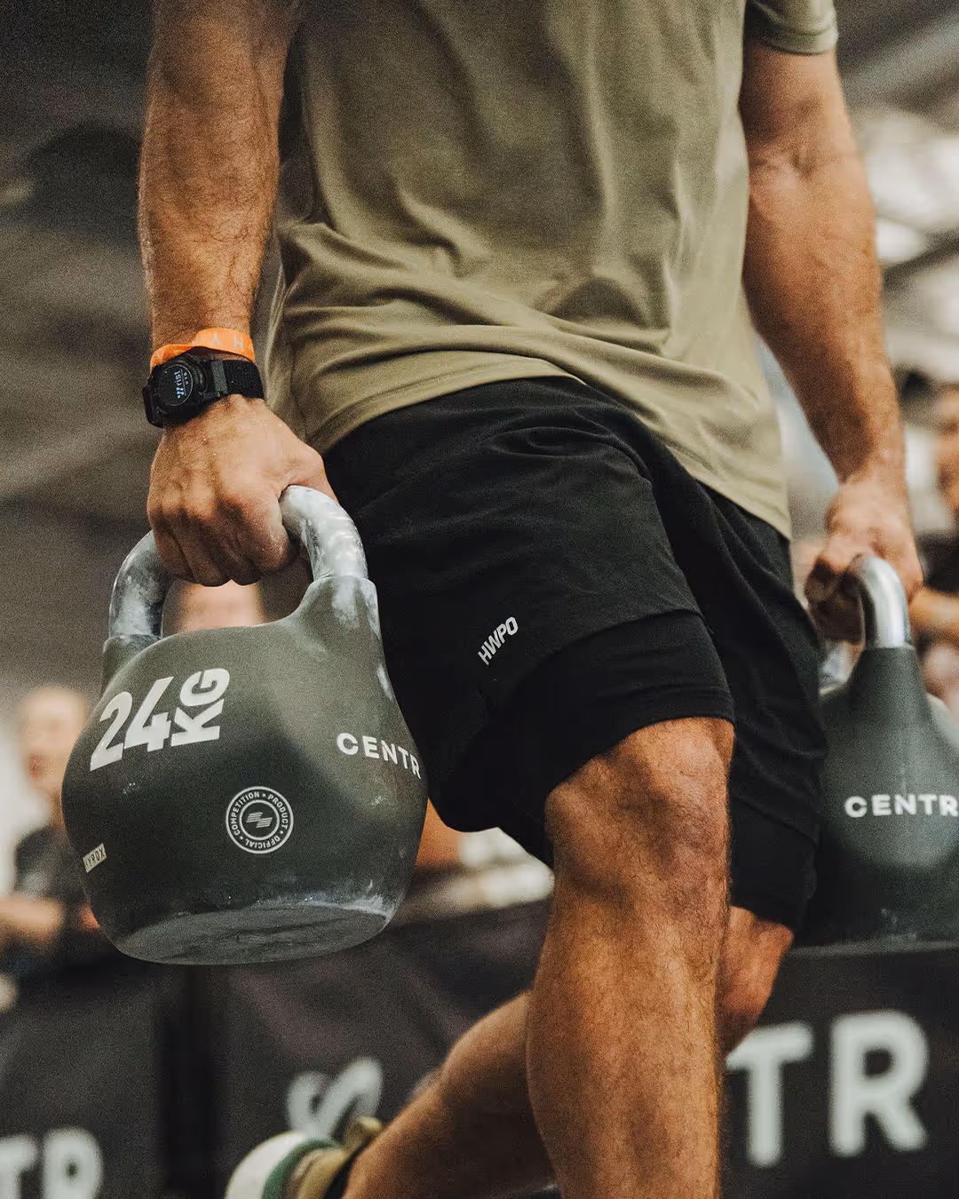 Close-up of a person holding two kettlebells.
