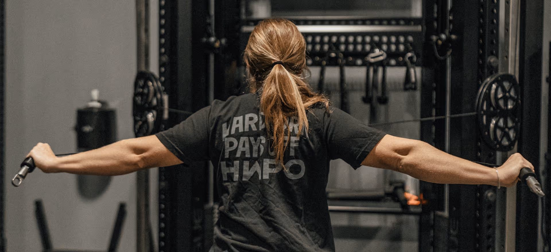 Person performing cable machine exercise in a gym.