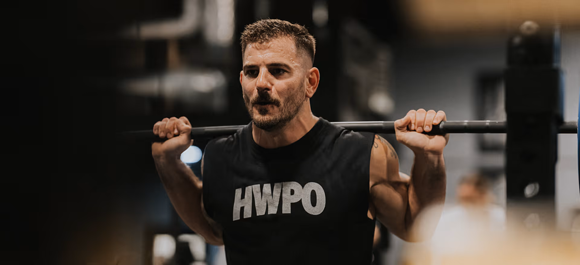 Mat Fraser lifting a barbell on his upper back.