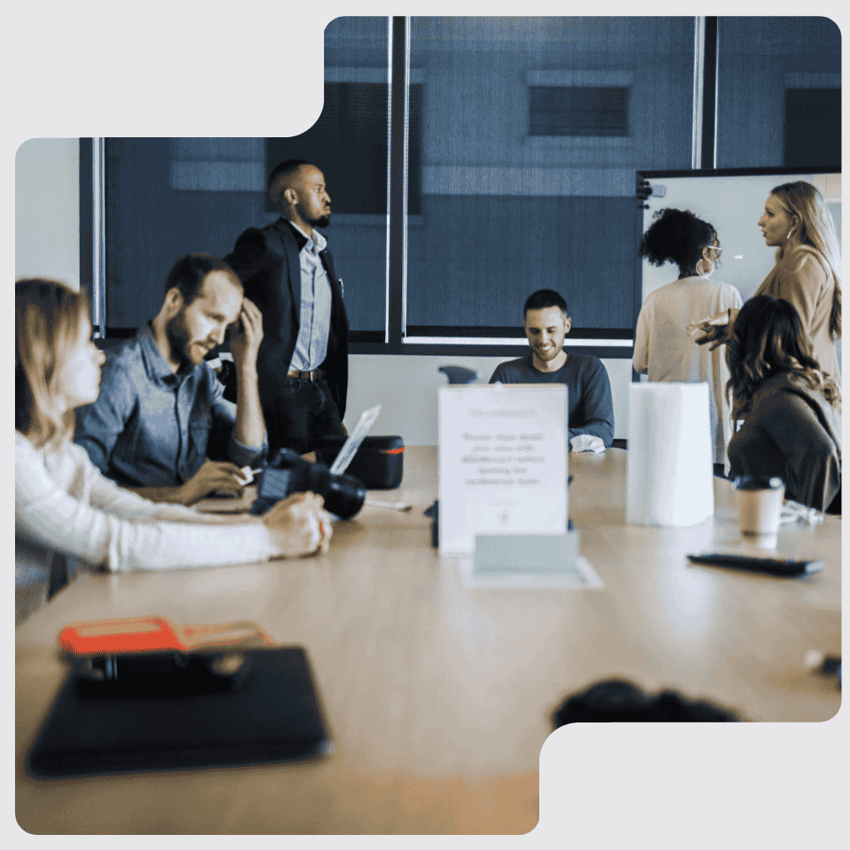 Group of diverse professionals engaged in a meeting around a conference table in a modern office.