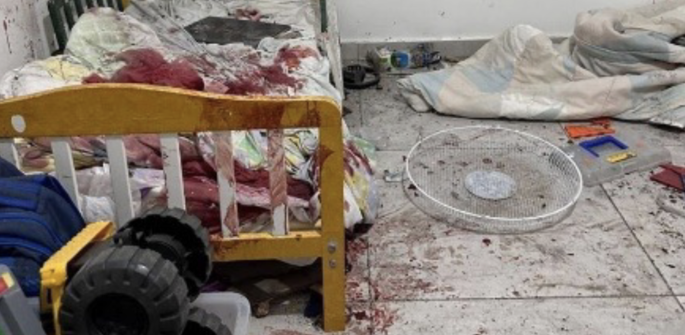 A blood-stained floor with a baby's crib