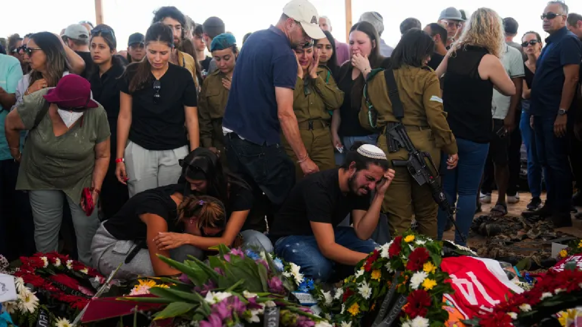 Families over grave at funeral in Israel