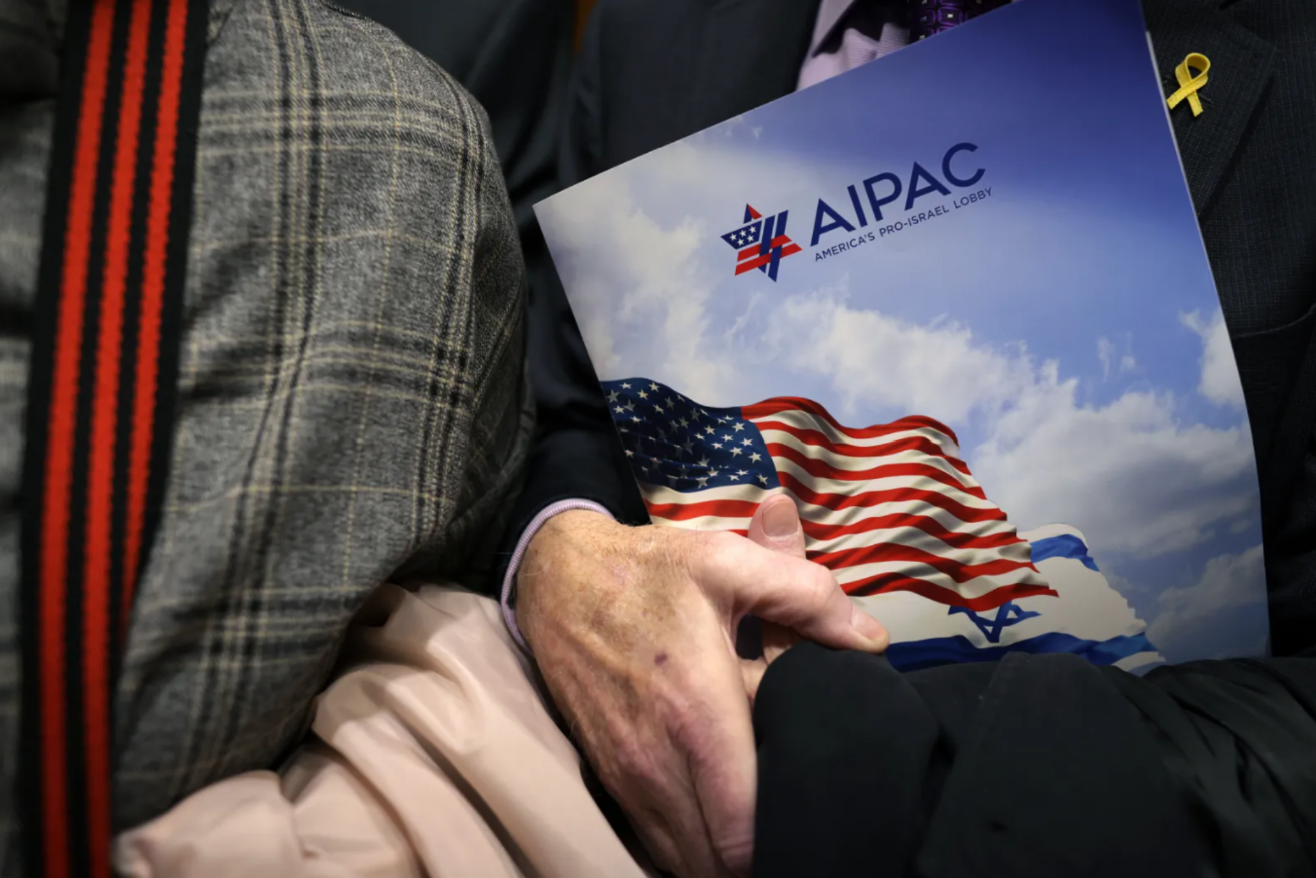 A person holding an AIPAC folder.