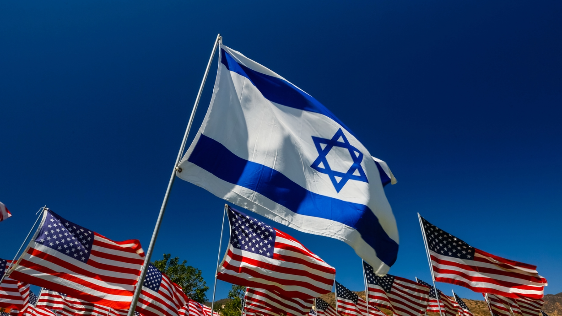 Israeli flag flying with American flags.
