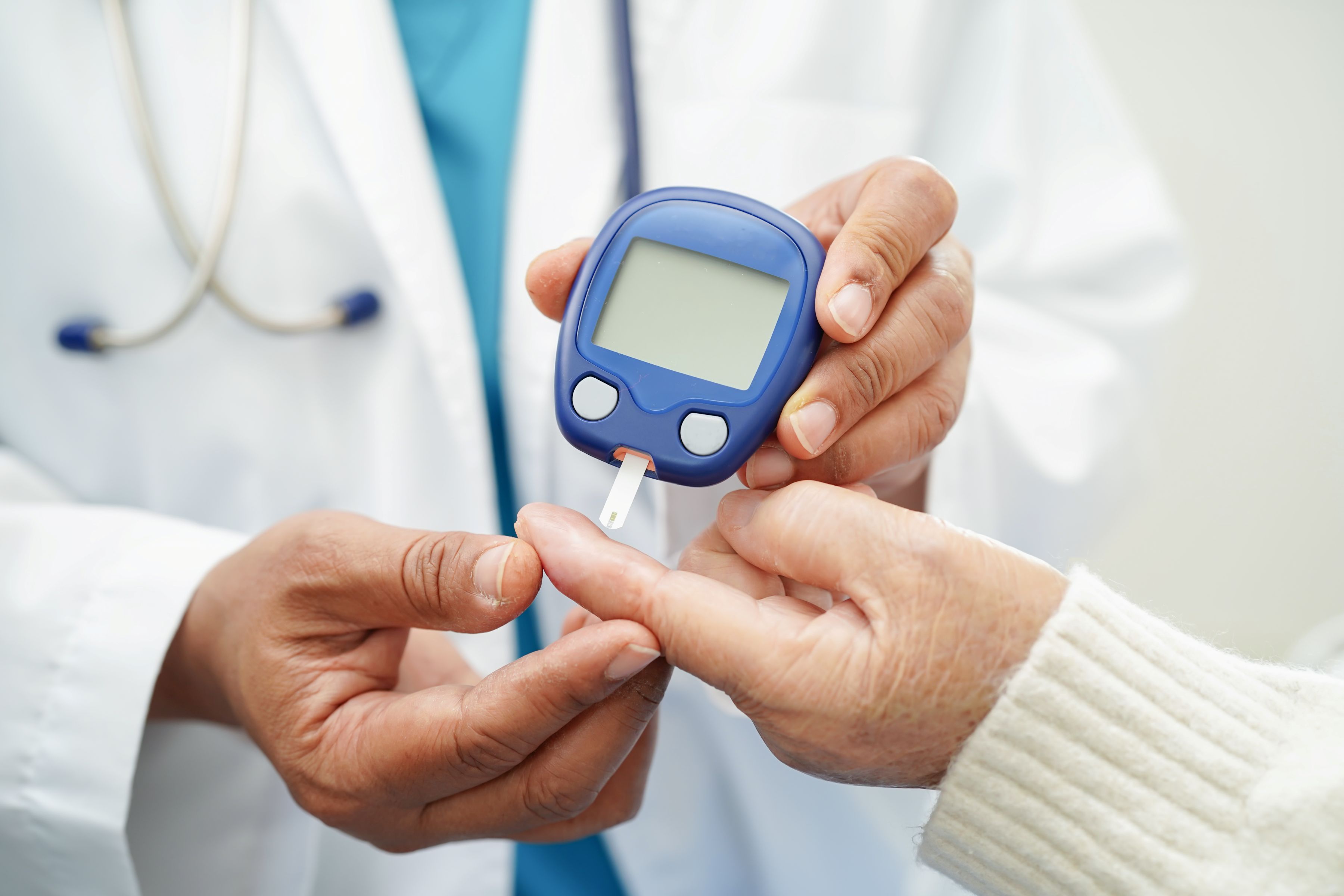 A doctor administers a blood sugar test to a patient.