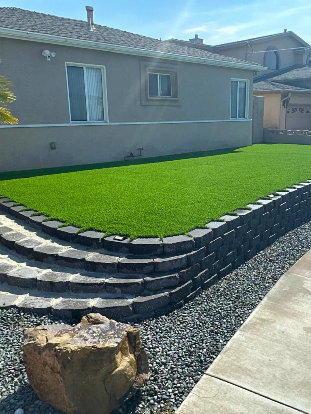 Residential drainage grading with retaining wall and turf installation