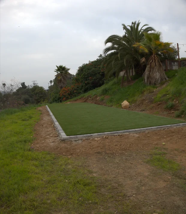 Outdoor play area with artificial turf on a graded landscape