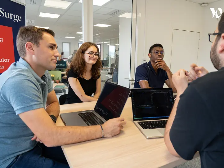 male holds a luminous labs red light therapy panel for a user, the light targets the face, the user is female and is smiling as the light rays feel good