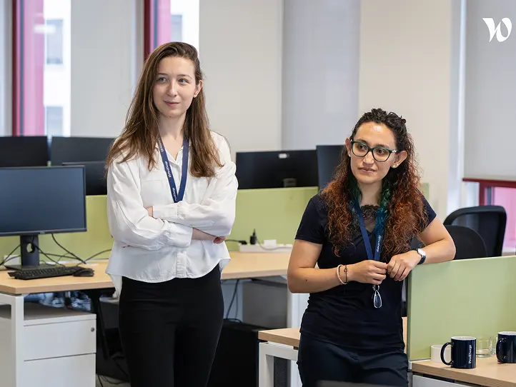 male holds a luminous labs red light therapy panel for a user, the light targets the face, the user is female and is smiling as the light rays feel good