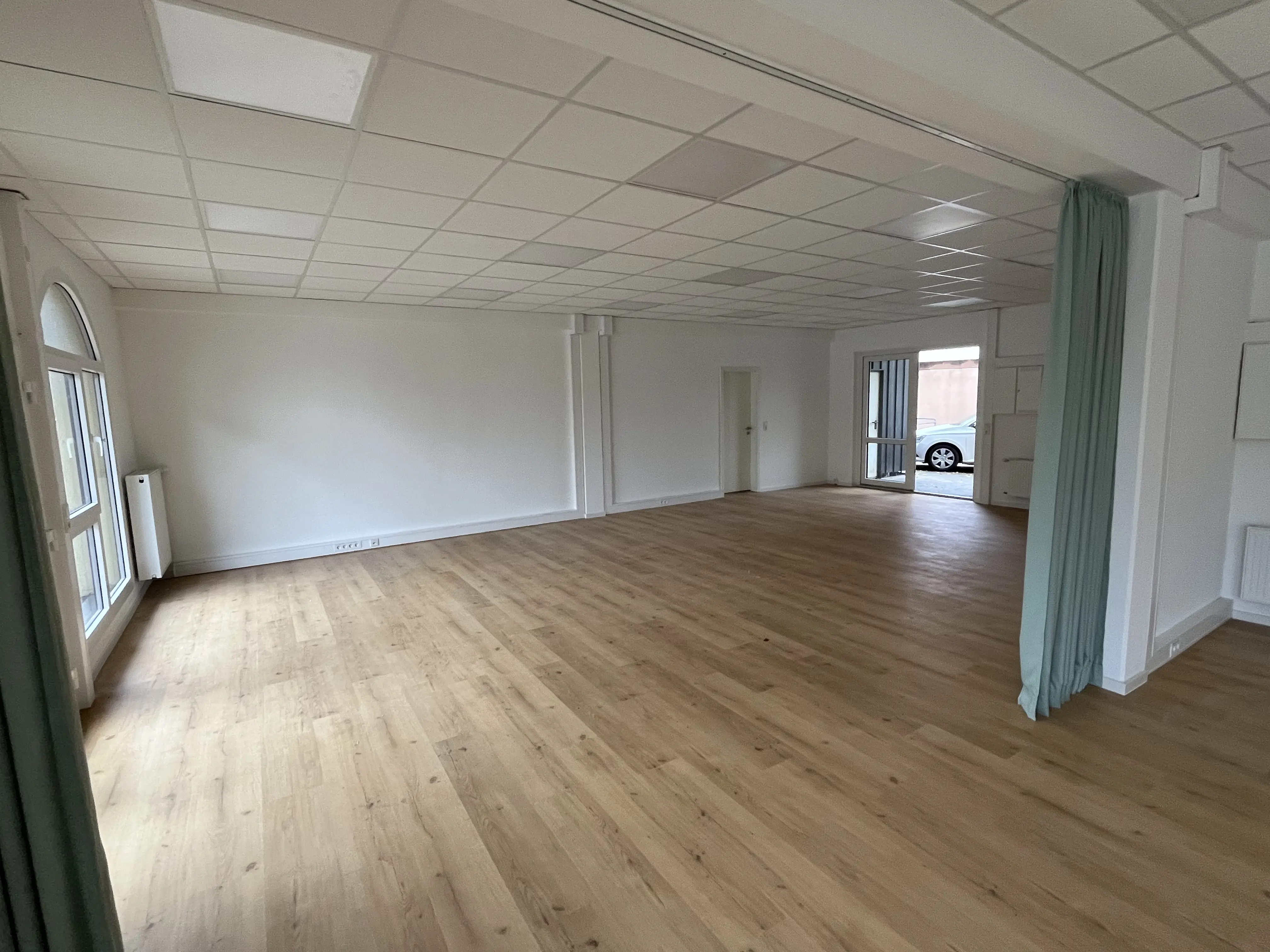 Empfangsraum im IVITALIS Studio Braunschweig-Querum mit geöffnetem Vorhang und Blick in den Kursbereich