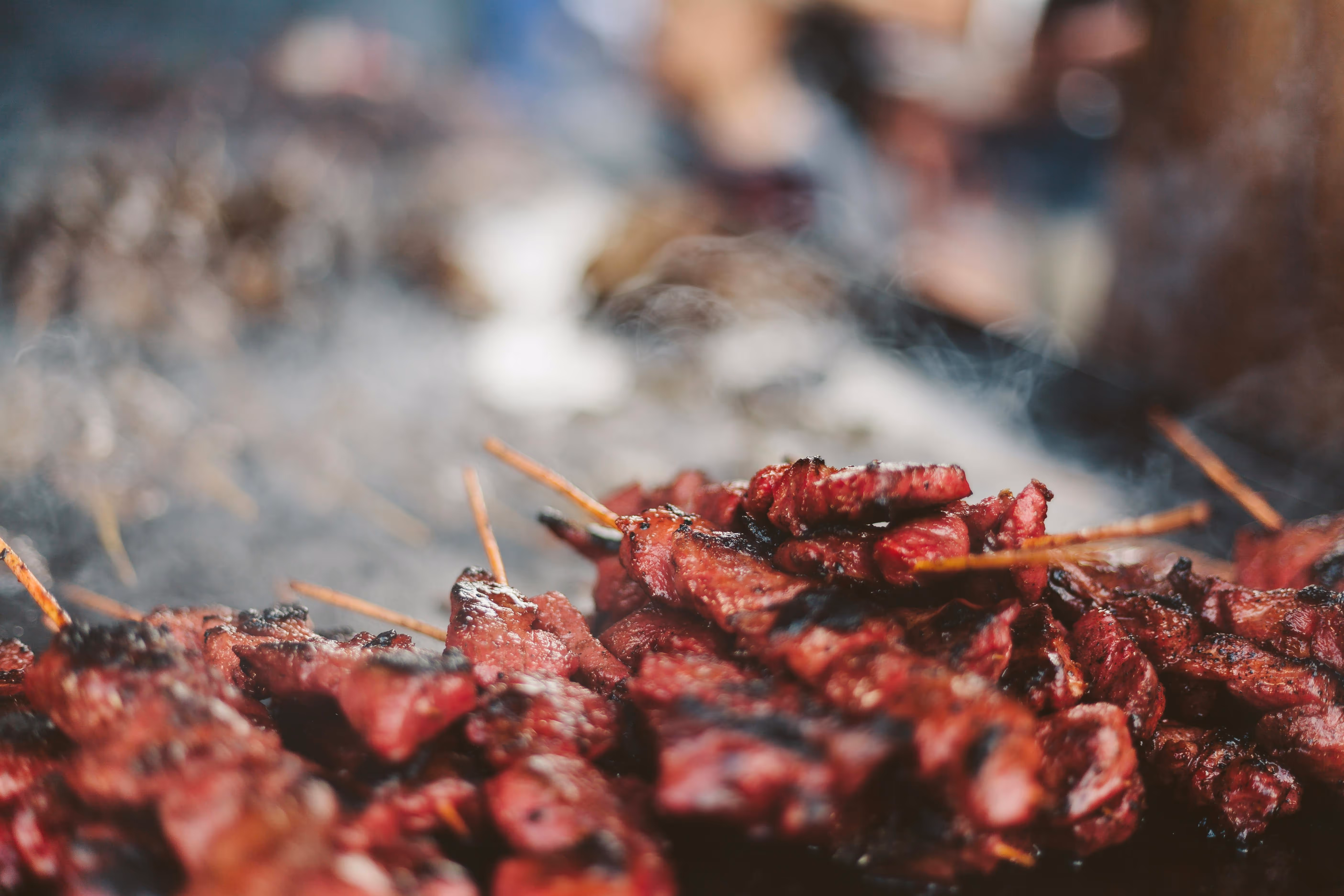 Gegrilde spiesjes met sappig rood vlees op een barbecue met rook.