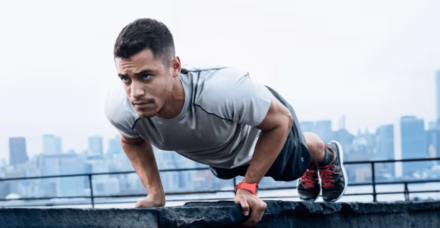 Fit man doing push-ups outdoors, representing strength, energy, and performance benefits discussed in a man’s guide to TRT.