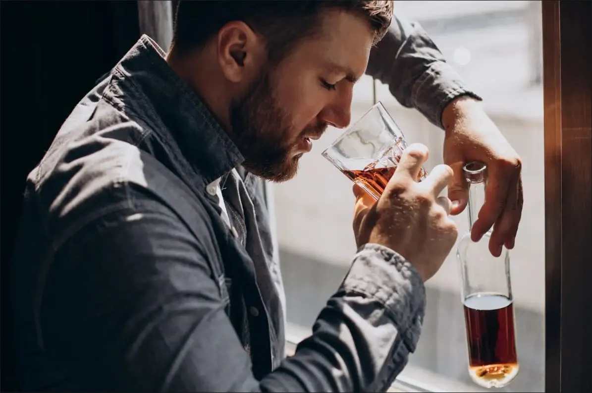 Man drinking alcohol, considering the possible link between alcohol consumption and erectile dysfunction.