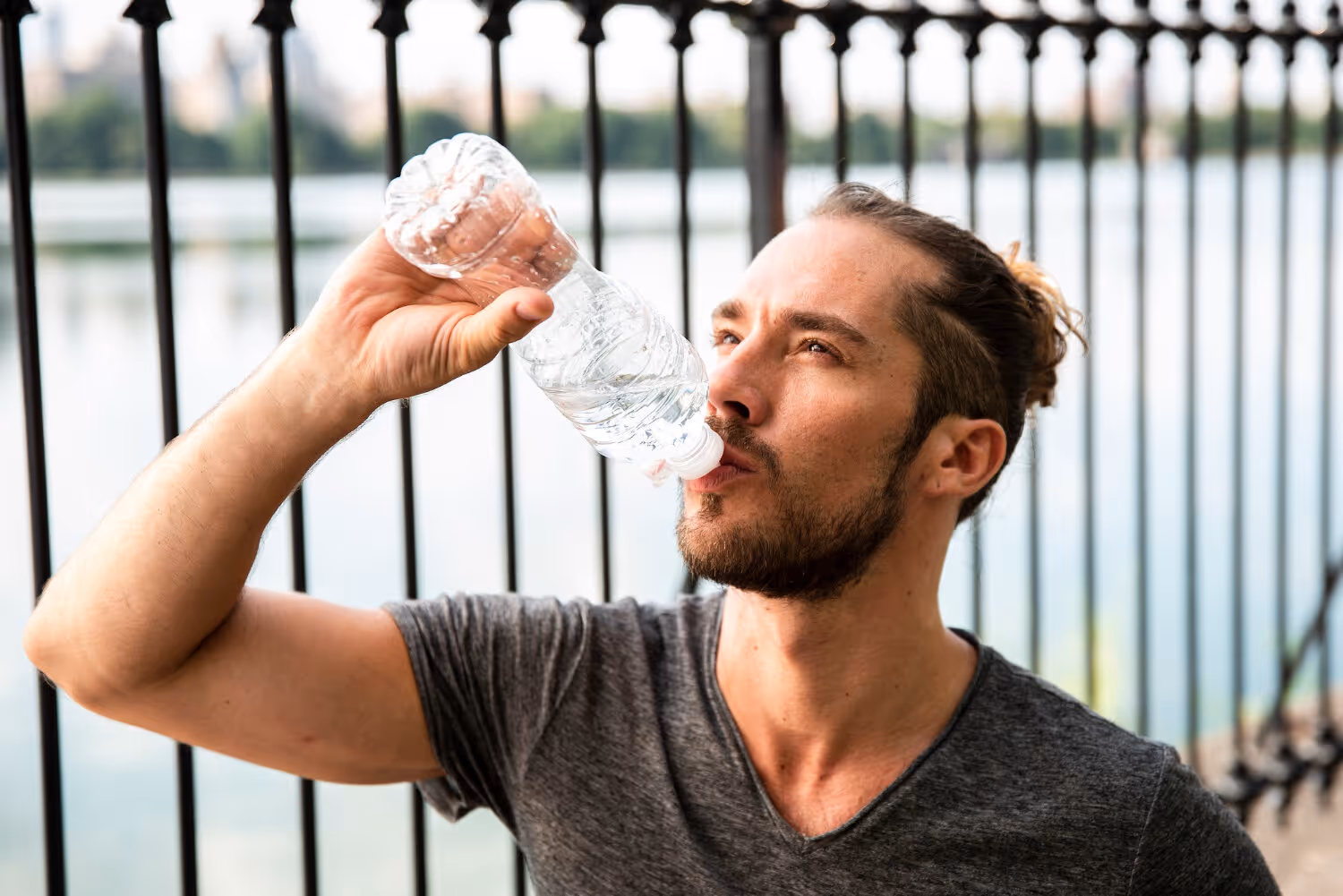 Man drinking water outdoors to stay hydrated while managing hormone balance and fertility during Clomid treatment for men.