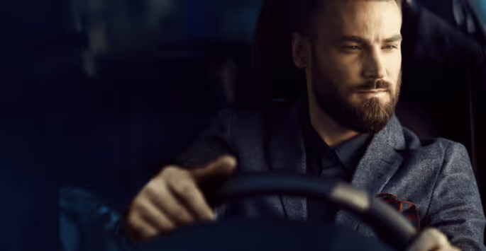 Confident man driving a car, symbolizing renewed energy, focus, and vitality that show how bioidentical hormone therapy could rejuvenate you.