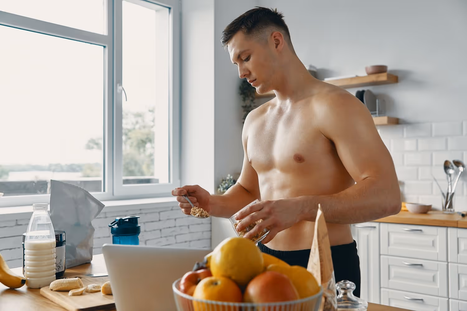 A toned man in a modern kitchen, surrounded by healthy foods and drinks, promoting metabolic health.