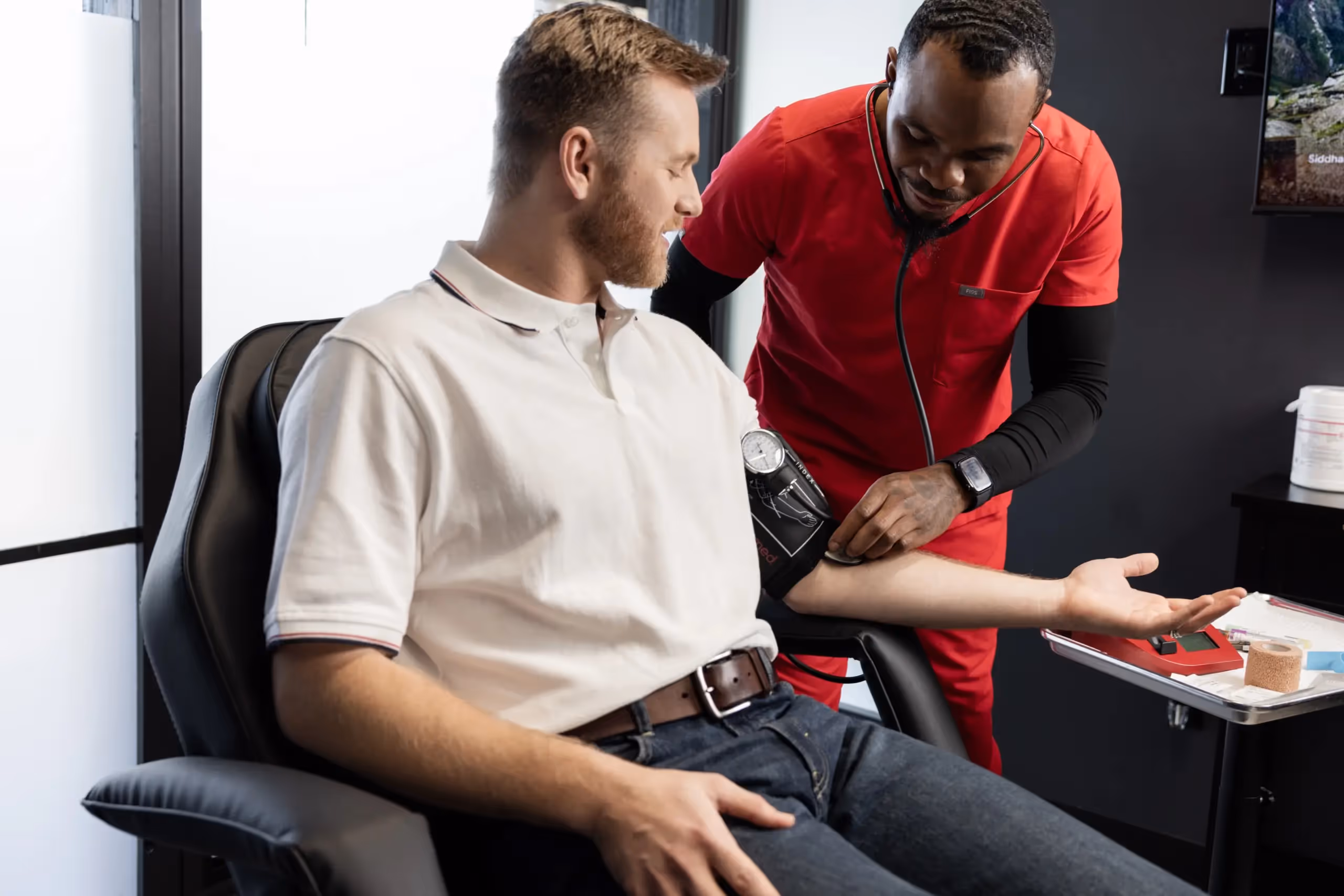 Healthcare provider checking a patient’s blood pressure in a clinical setting, representing medical evaluation and personalized care associated with shockwave therapy treatment.