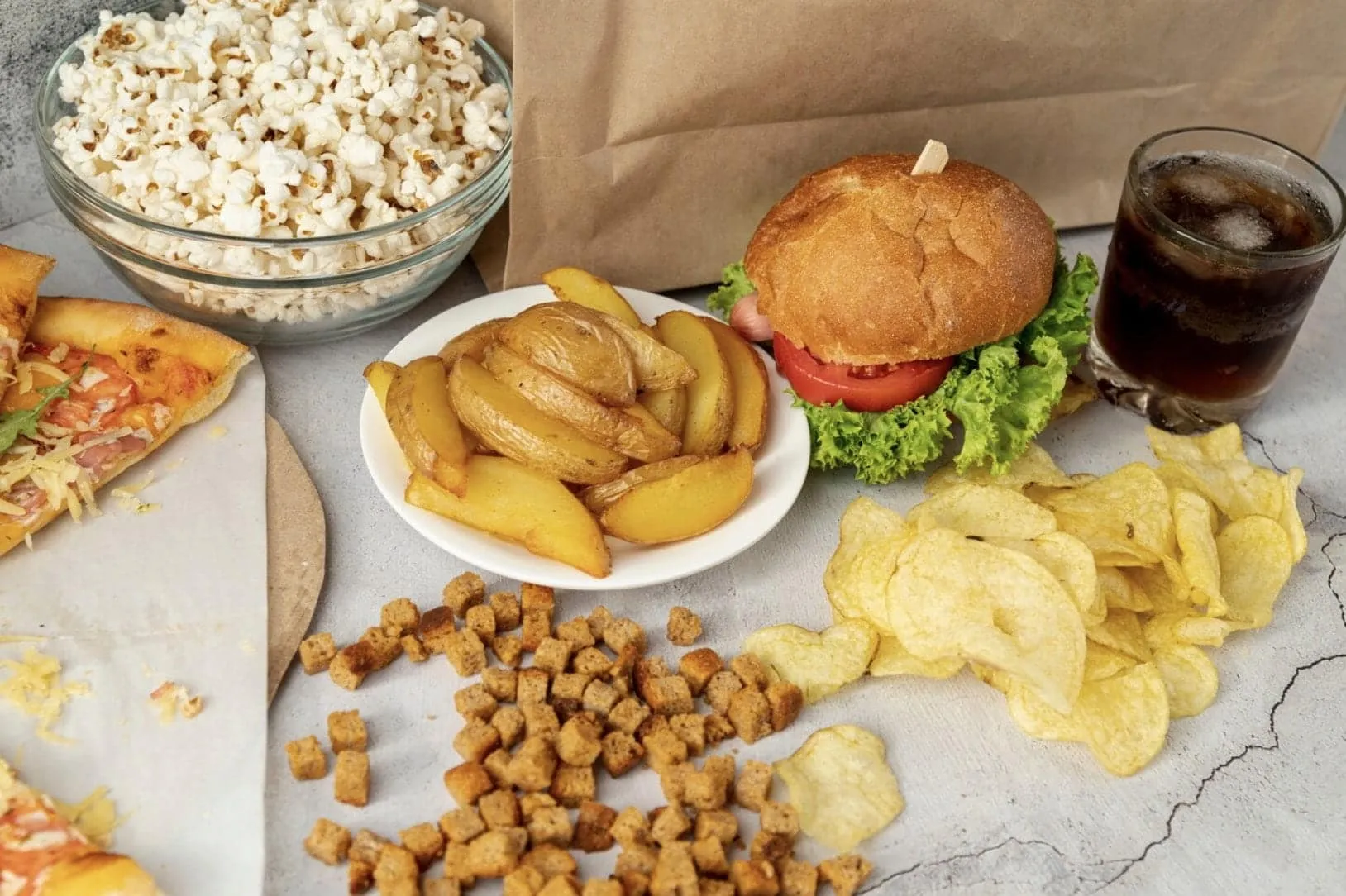 A close-up of unhealthy foods like fried chicken, burgers, and sugary drinks that contribute to poor blood circulation and worsen erectile dysfunction symptoms in men.