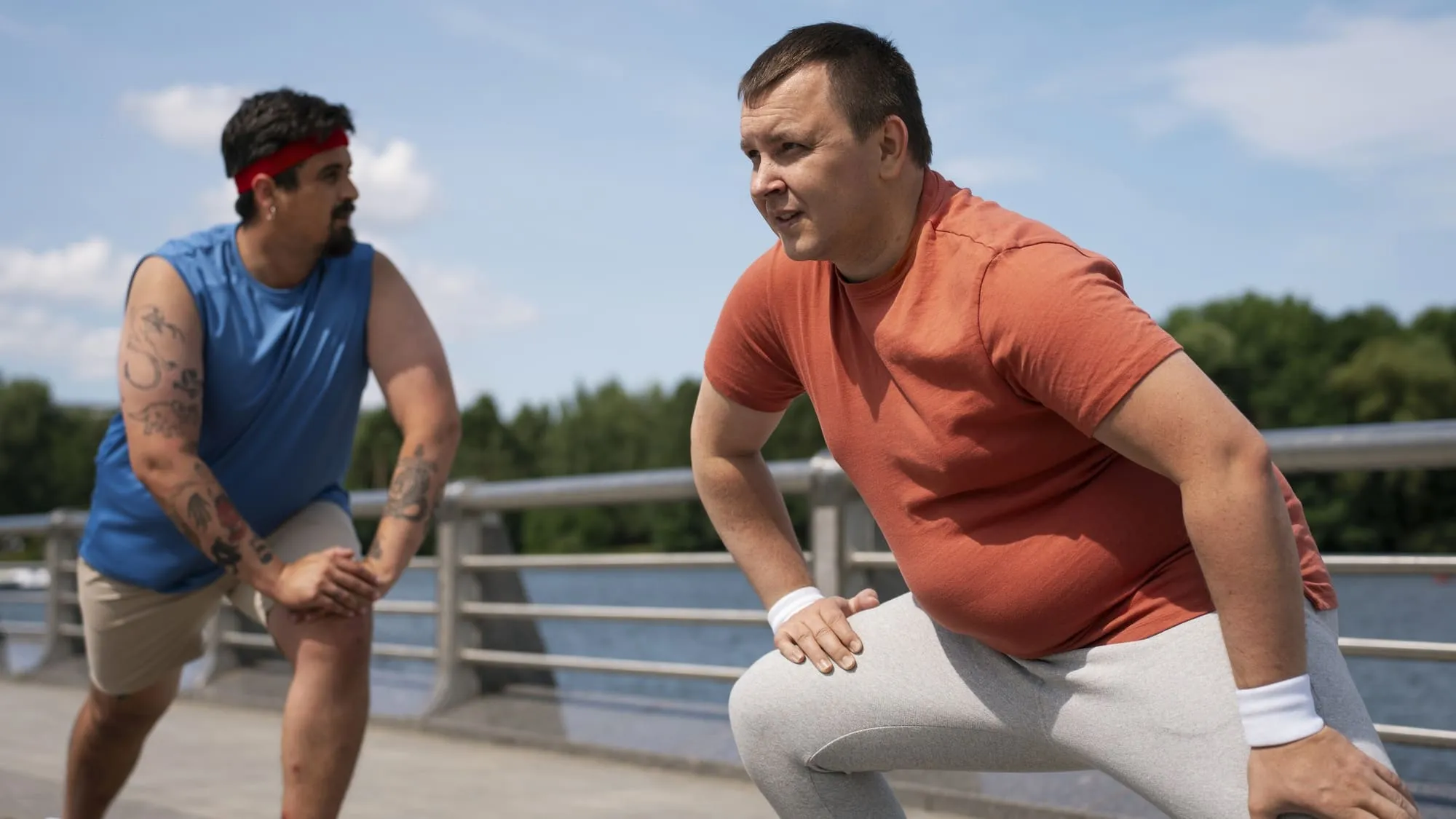 Two men stretching outdoors before a workout as a part of their weight loss journey combined with weight loss injections.