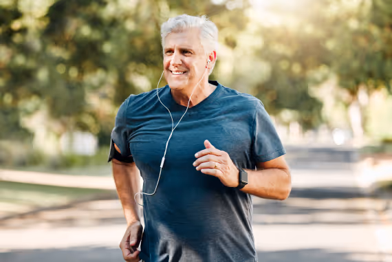 An active older man running outdoors, smiling and enjoying physical activity, reflecting the vitality and performance that can be enhanced through treatments like the P-Shot.