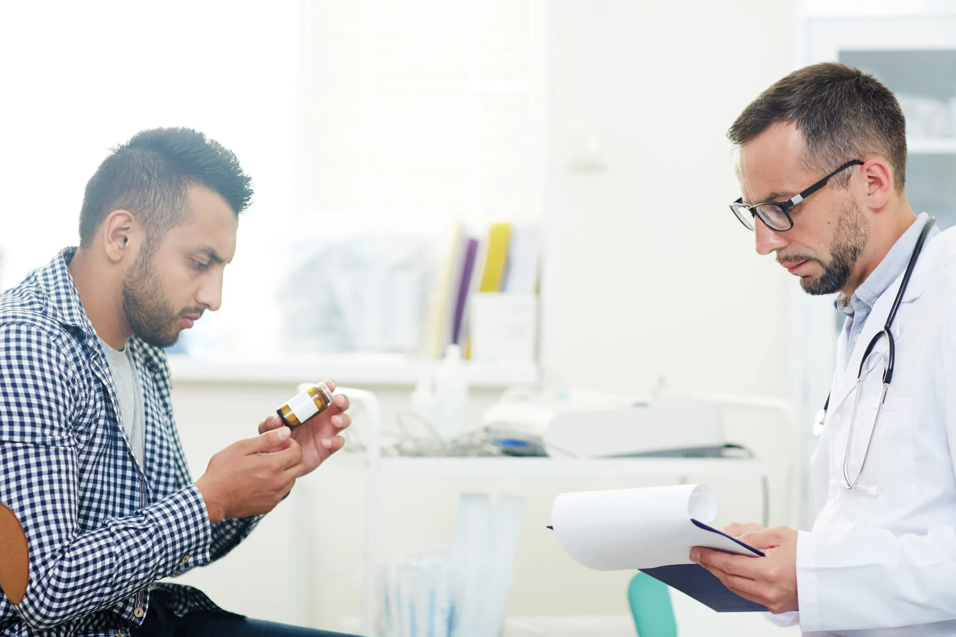 A patient reviewing medication with a healthcare provider, symbolizing the importance of selecting a trusted and knowledgeable men's health provider.