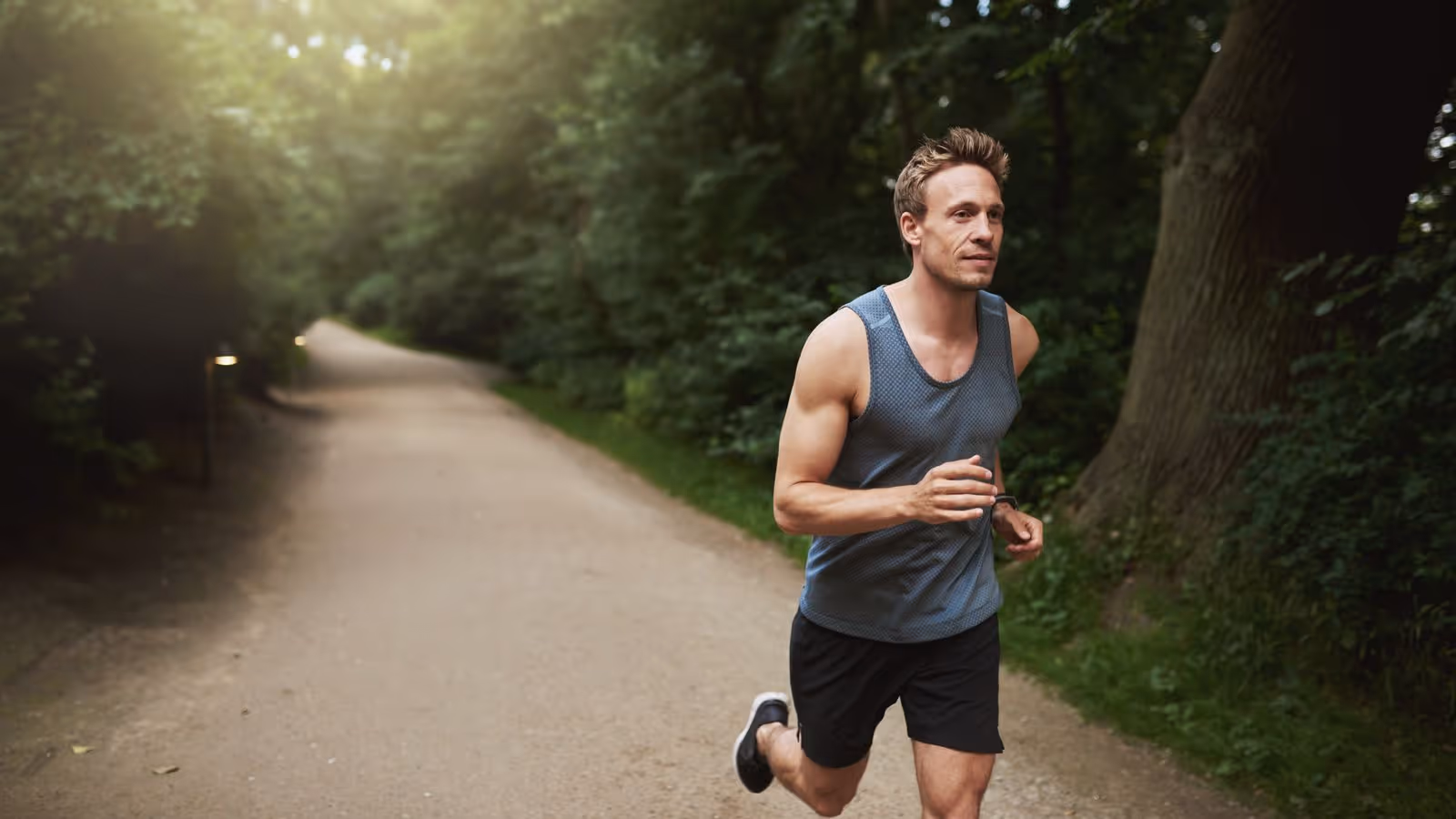 A man running in the park, representing the impact of maintaining physical health and well-being, which may be affected when stopping medications like Enclomiphene that help regulate hormone levels.