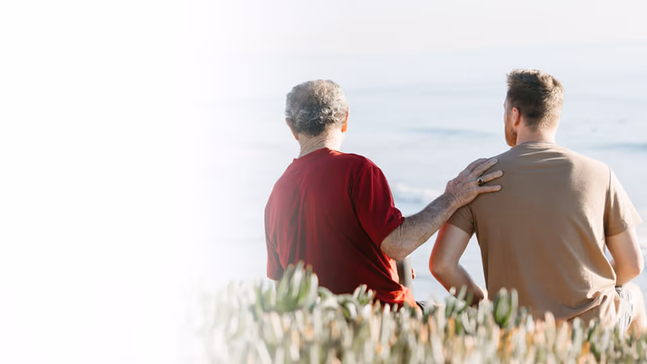 Elderly man and younger man enjoying a peaceful moment together by the ocean, symbolizing the importance of maintaining health and vitality, potentially supported by Vitamin C for overall wellness.