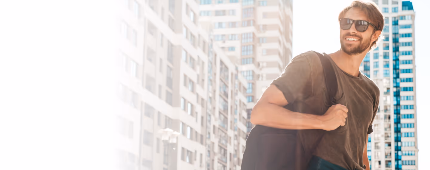 Confident man walking through a city with a backpack, representing increased vitality, recovery, and overall wellness benefits associated with sermorelin peptide therapy.