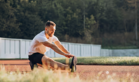 Active man stretching on an outdoor track, symbolizing proactive men’s health, early detection, and wellness success highlighted in a PSA screening Gameday success story.