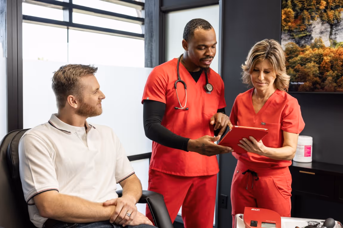 Male patient consulting with healthcare providers reviewing medical information, illustrating discussions around testosterone replacement therapy safety and why more men are choosing TRT.