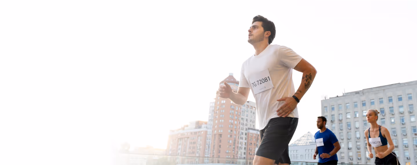 Man running in an outdoor race with other athletes, representing increased energy, endurance, and performance benefits associated with HGH therapy for men.