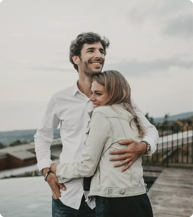 Smiling couple hugging outdoors, symbolizing the restored confidence, intimacy, and relationship satisfaction supported by GAINSWave® shockwave therapy.
