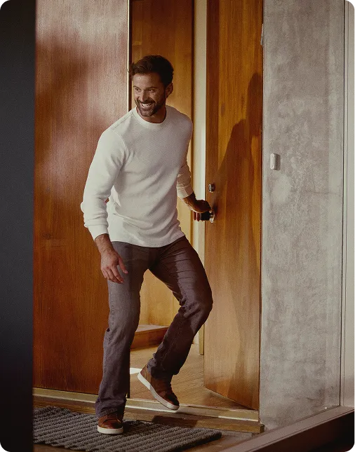 Smiling man walking through the front door, representing renewed energy, mood, and vitality after starting Testosterone Cypionate injection therapy.