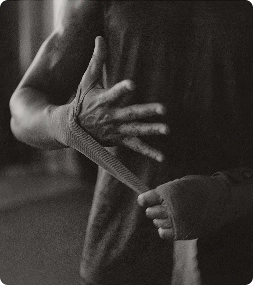 Athlete wrapping his hand before training, benefiting from shockwave therapy for sports injury recovery.