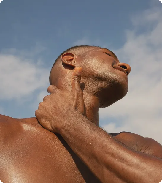 Fit man outdoors touching his neck after exercise, representing immune support and antioxidant benefits of Vitamin C injections.
