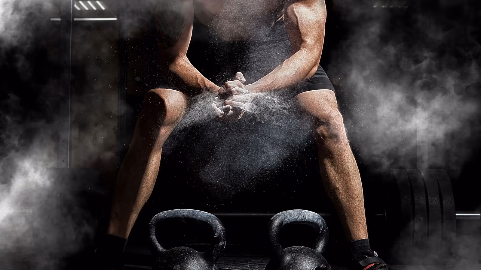 Skier in blue jacket on a sunny slope with snowy peaks in background.