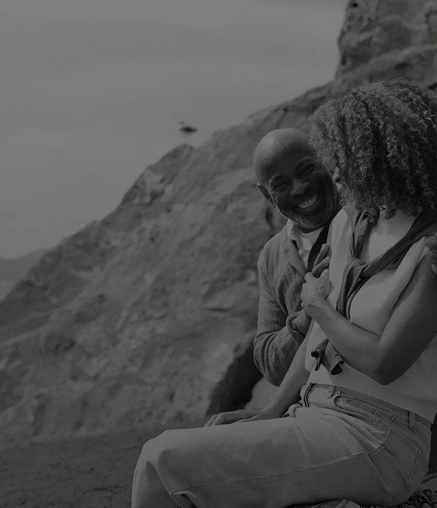 Smiling couple sitting together in the mountains, symbolizing restored intimacy, confidence, and sexual wellness supported by Gameday Men’s Health ED treatments.