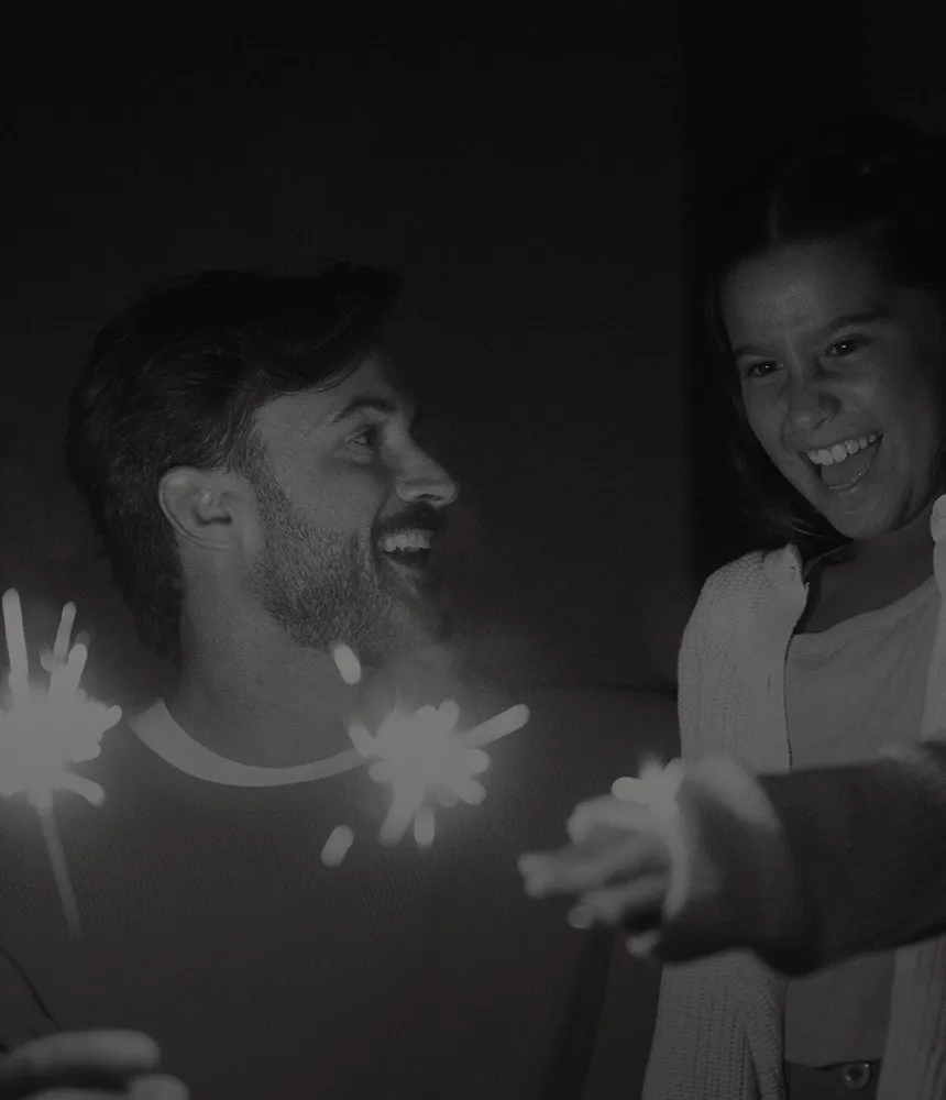 Smiling father and daughter celebrating outdoors with sparklers, reflecting the long-term benefits of anti-aging and hormone optimization at Gameday Men’s Health.