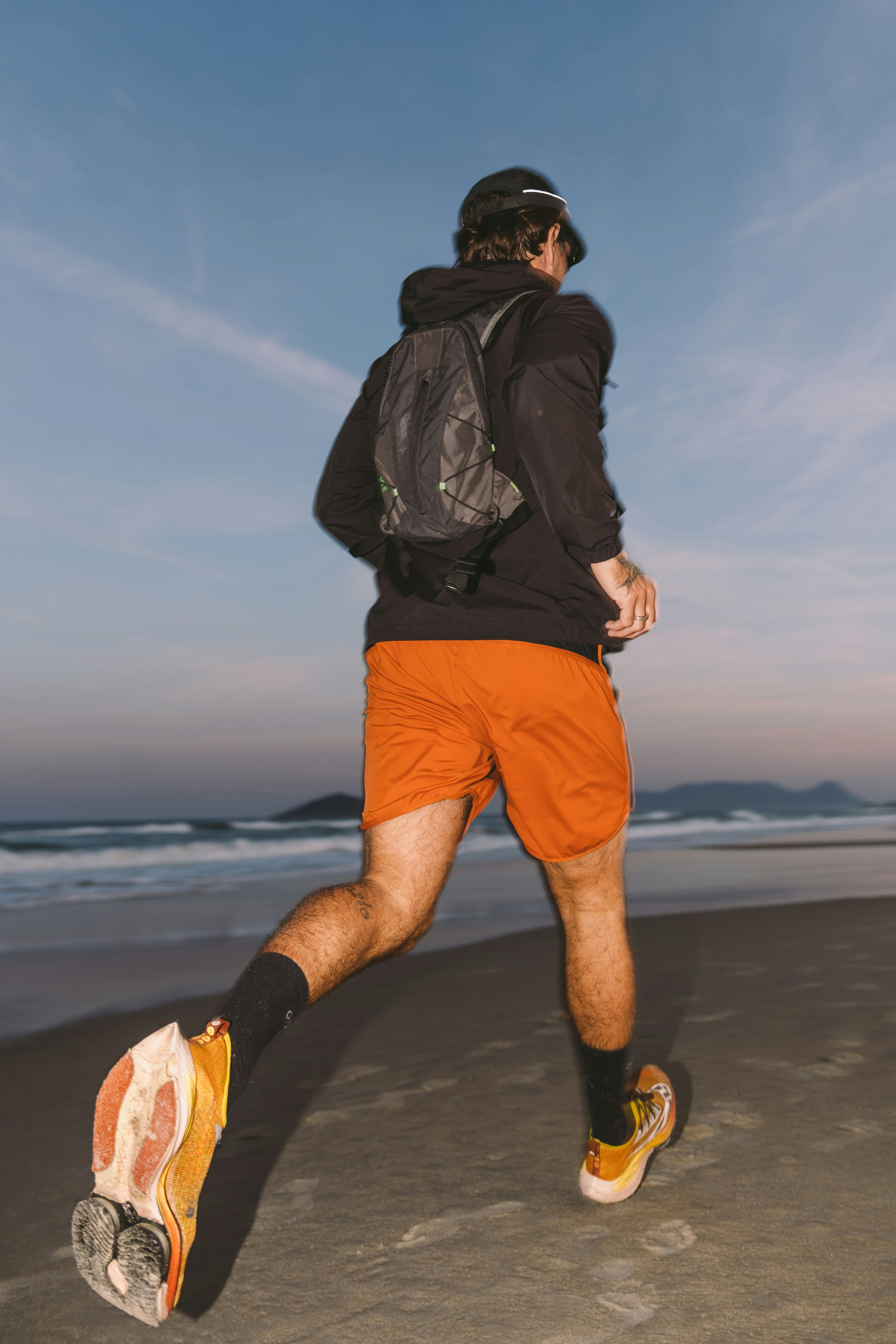 Man running on the beach, representing energy, performance, and vitality supported by NAD+ injection therapy