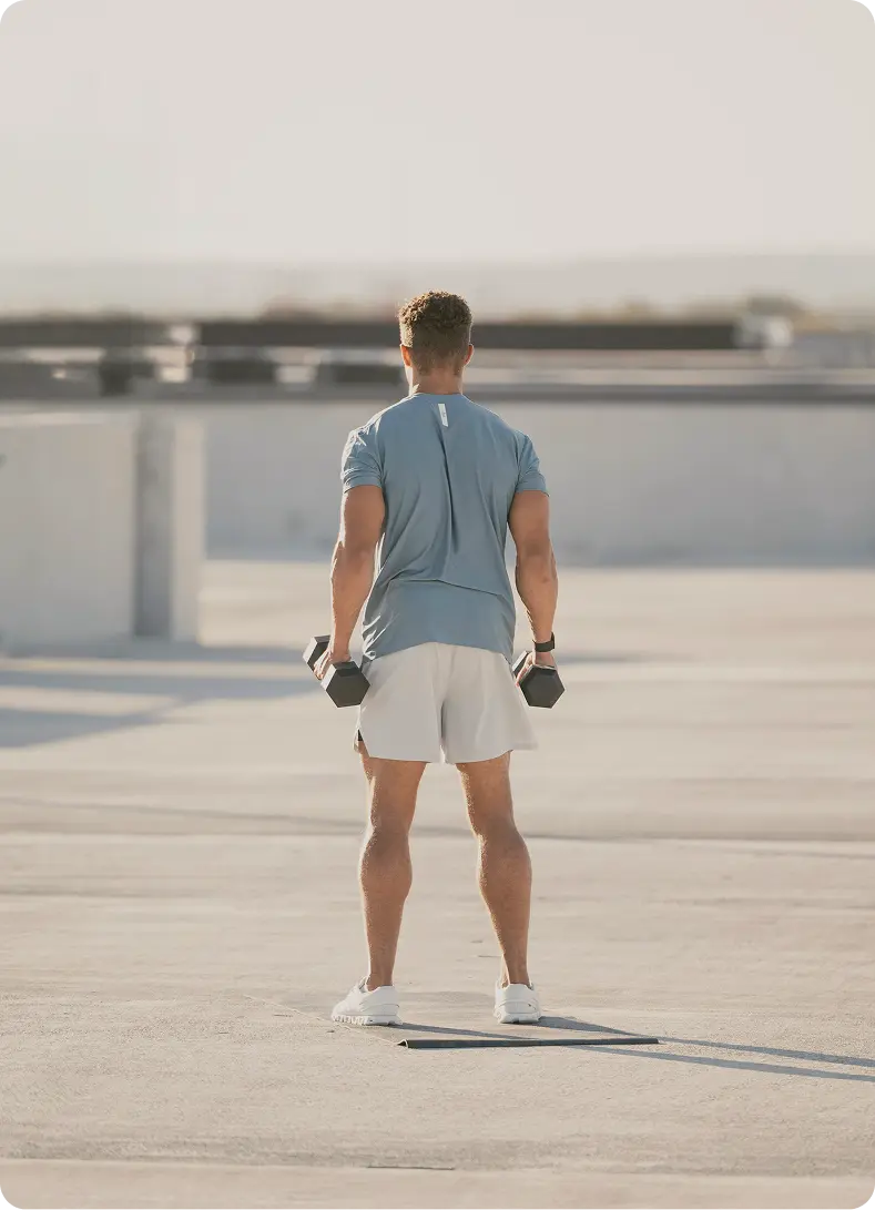 Man performing resistance exercises with dumbbells, reflecting active lifestyle habits and personal commitment supported alongside Semaglutide in West Edmonton, AB at Gameday Men’s Health.
