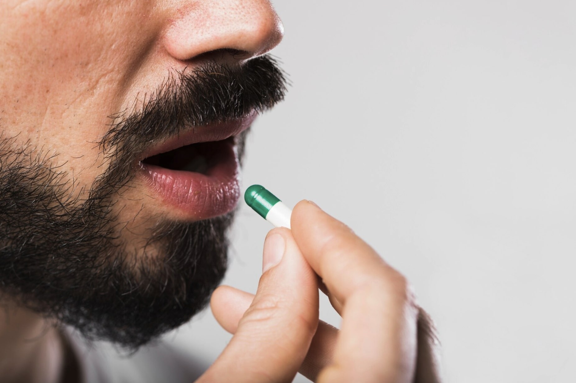 Man taking an oral TRT medication while considering side effects and long-term hormone health.