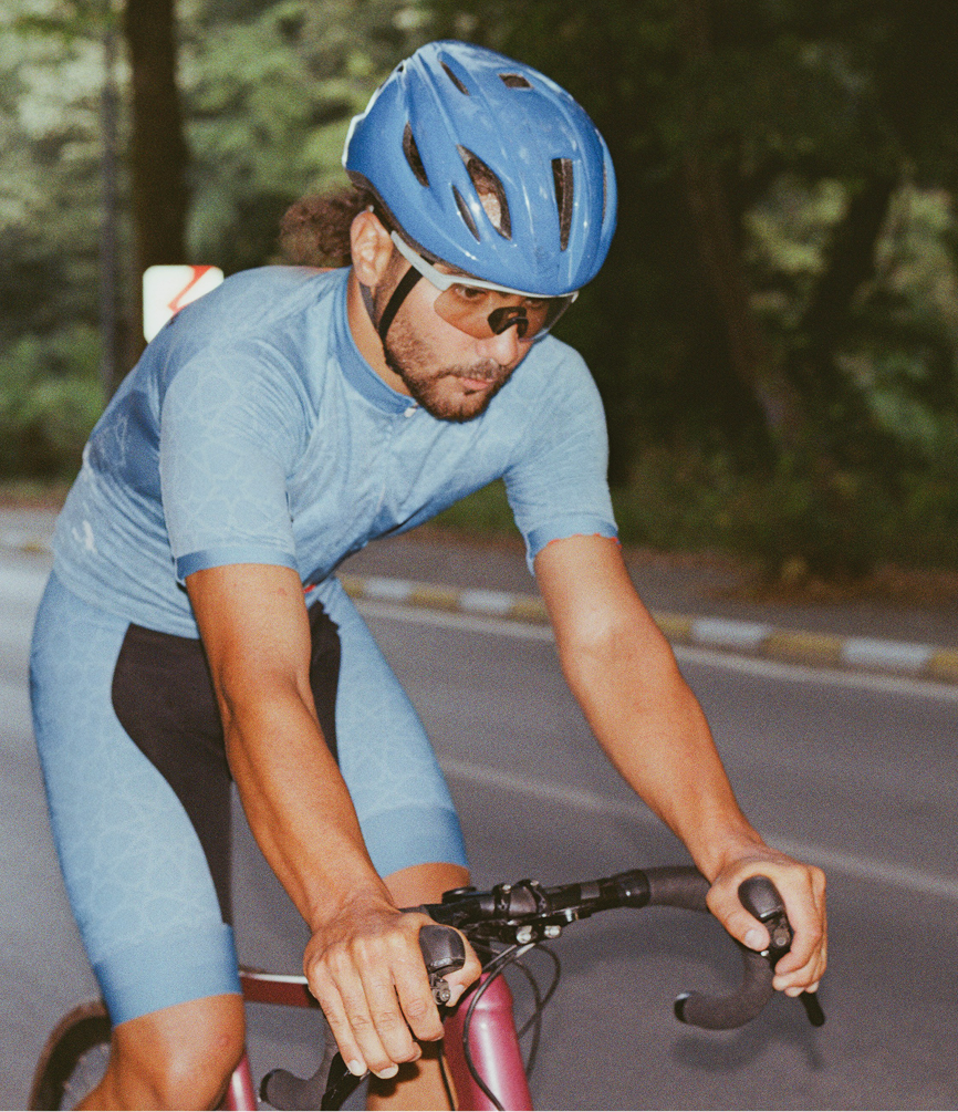 Man riding a bicycle on an open road, representing endurance, focus, and vitality supported by NAD+ injection therapy in Burlington, NC.